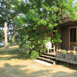 Cottage exterior with flower boxes and steps up from the lawn