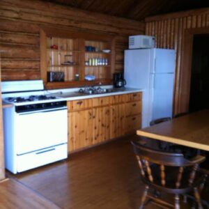 Full cottage kitchen with stove, fridge and dining table