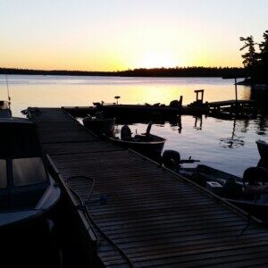 Boats tied at the King Island dock under a Lake of the Woods sunset