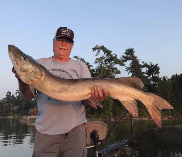 Angler on the dock holding a trophy muskie caught on Lake of the Woods